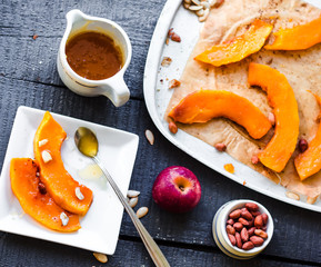 baked pumpkin slices with cinnamon and nuts, spoon with honey