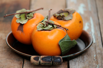 Fresh ripe persimmon on a wooden table