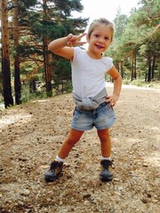 Young girl doing the victory sign in the mountains