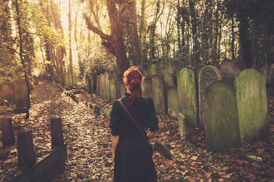 Woman walking amongst tombstones