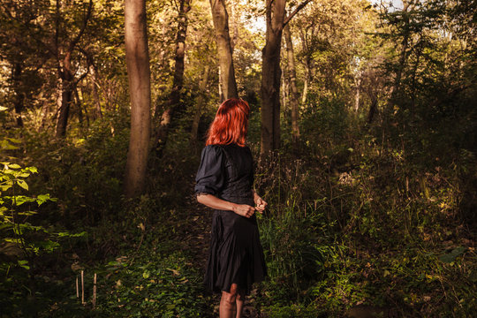 Young redhead woman in the woods