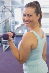 Fit brunette working out with dumbbells