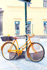 Orange provence rural bicycle with fruits in wicker basket.