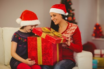 Festive mother and daughter opening a gift