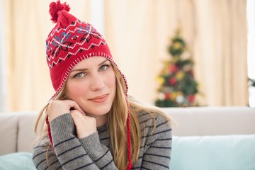 Pretty blonde in winter clothes sitting on the couch