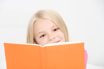 Cute little girl is reading book