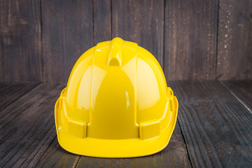 Construction hard hat on wooden background