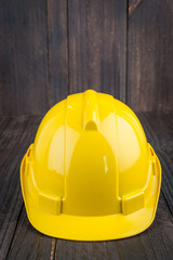 Construction hard hat on wooden background