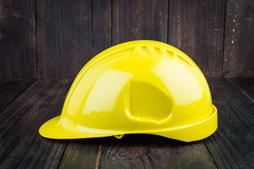 Construction hard hat on wooden background