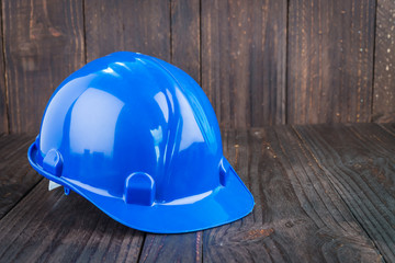 Construction hard hat on wooden background