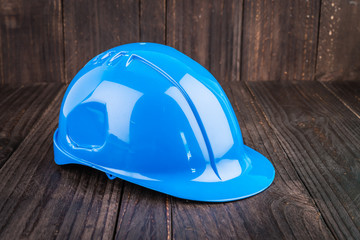 Construction hard hat on wooden background