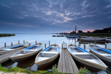 Fototapeta premium boats on lake harbor at sunrise