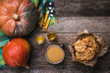 Rustic style pumpkins, soup, honey and cookies with nuts on wood