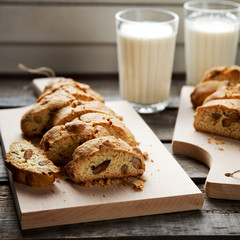 Homemade nut cookies on a board with the milk in the background