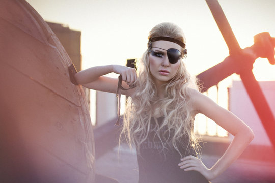 Fashion woman with long blond hair, make up and eye-patch