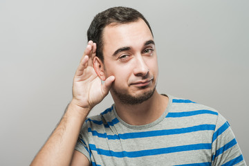 Man holds his hand near his ear and listening something