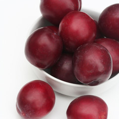 prugne rosse su sfondo bianco_ frutta