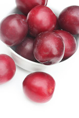 prugne rosse su sfondo bianco_ frutta