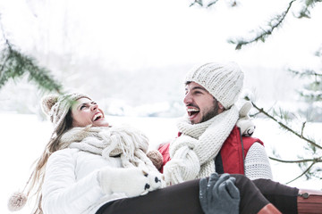 Obraz premium Mann trägt lachende Frau im Winter