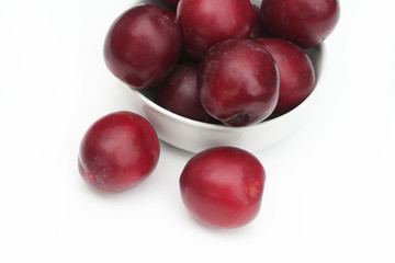 prugne rosse su sfondo bianco_ frutta
