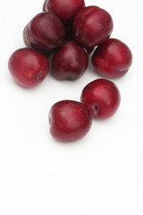 prugne rosse su sfondo bianco_ frutta