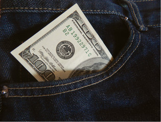 banknote of one hundred dollars in dark blue jeans pocket