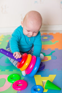 Cute little baby playing with colorful toys