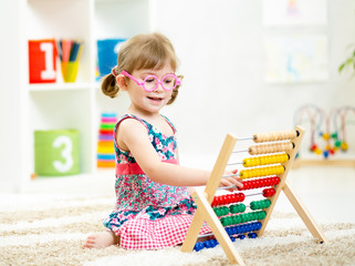 child girl with eyeglasses playing abacus toy