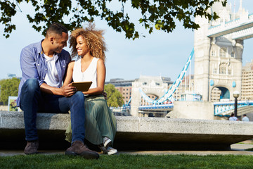 Couple Using Digital Tablet With Tower Bridge In Background