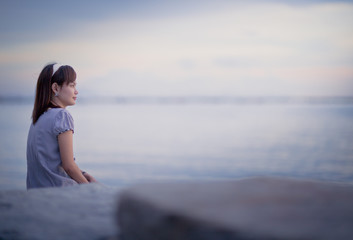 Beautiful young woman on sea in twilight