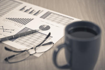Business report. Cup of coffee and document.