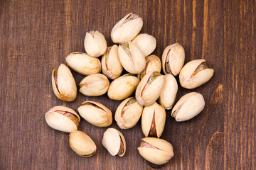 Pistachio nuts on wooden table seen from above