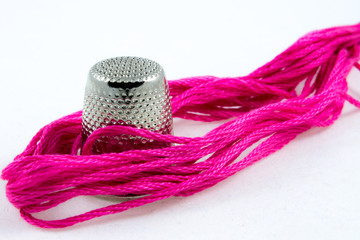 soft pink cotton thread and a thimble