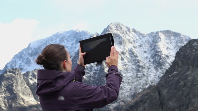 Woman hiker taking photo with digital tablet, Tatras, Slovakia