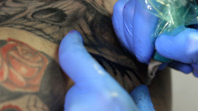 Tattoo artist tattooing a skull