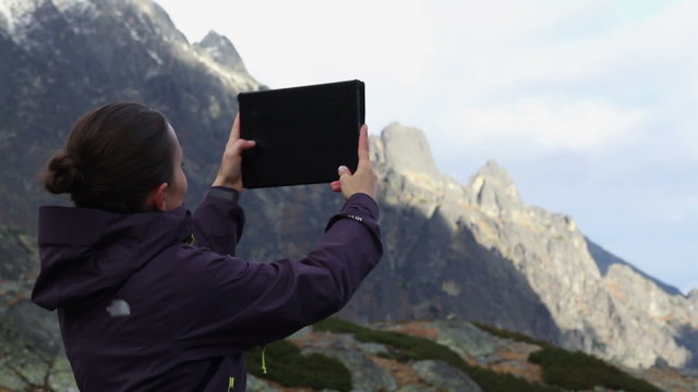 Young woman taking pictures on a tablet, Tatras, Slovakia
