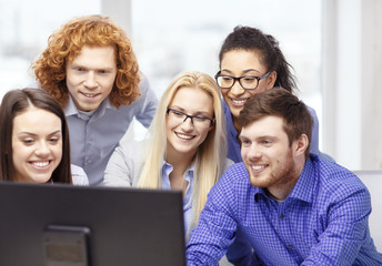 Fototapeta premium smiling business team looking at computer monitor