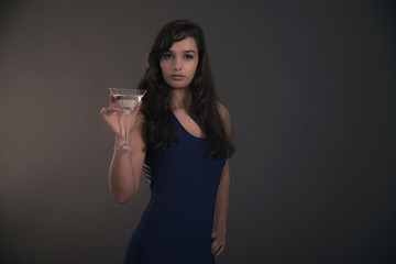 Pretty brunette teenage girl holding cocktail glass wearing blue