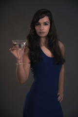 Pretty brunette teenage girl holding cocktail glass wearing blue