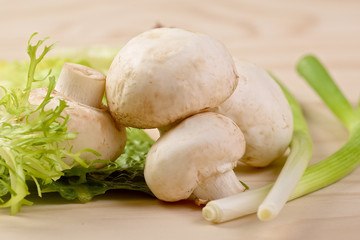 Bunch of fresh white mushrooms with a scallion
