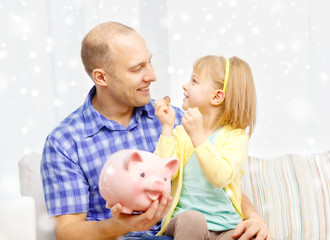 happy father and daughter with big piggy bank