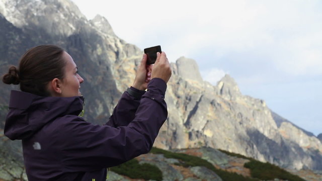 Woman uses a smartphone to video a beautiful view