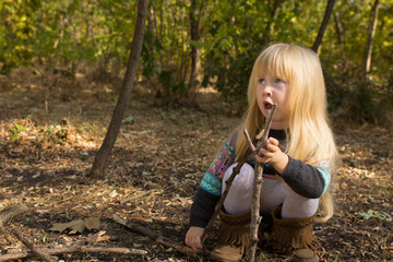 Young Girl Building with Sticks Outdoors in Autumn