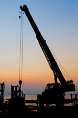 Silhouette crane working at port