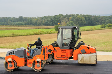 Zwei Walzen beim Bearbeiten von Asphalt