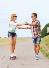 smiling couple with skateboard outdoors