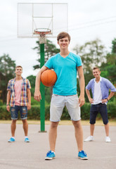 group of smiling teenagers playing basketball