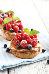 Sweet cakes with berries on table close-up