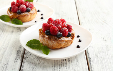 Sweet cakes with berries on table close-up