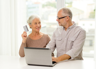 happy senior couple with laptop and credit card